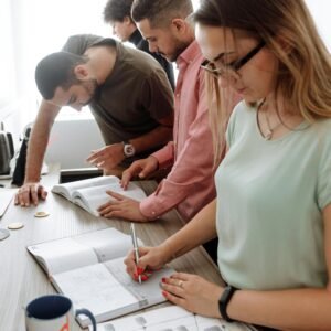 Group of young professionals collaborating on a project in a modern office setting.