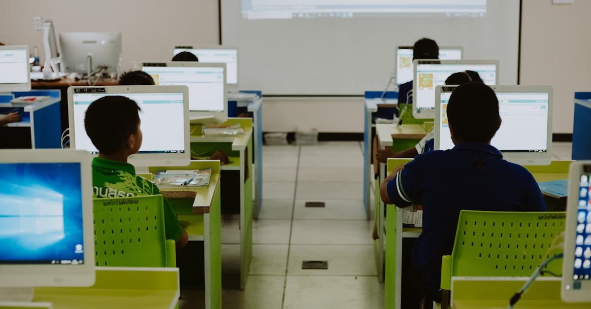 Children focus on computers in a modern classroom setting.